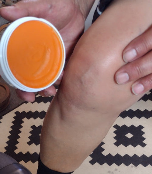 applying Ellys all natural pain cream to the knee